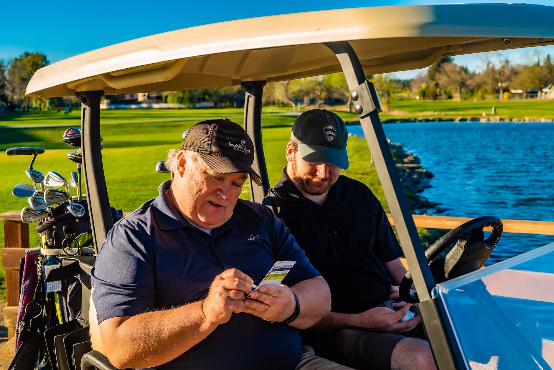 men sitting at the golf car while having conversation