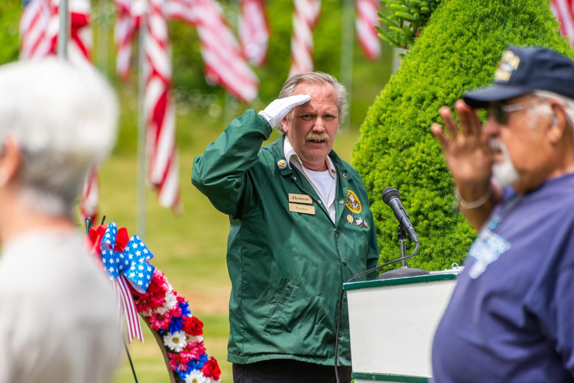 men making gesture showing respect at memorial service